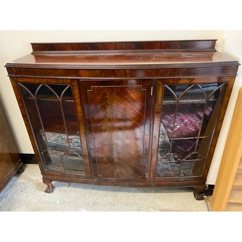 42 - A mahogany bow front display cabinet, fitted centre cupboard flanked by glass doors, on short cabrio... 