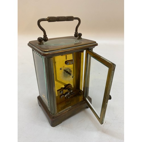 329 - A carriage clock with white enamel dial, in a bevelled glass and brass lacquered case - 4 1/2in. hig... 