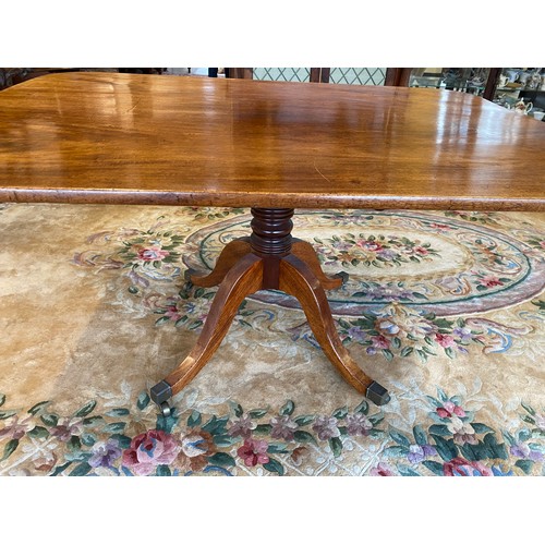 70 - A Georgian mahogany breakfast table with hinged rectangular top, on ring turned column and four down... 