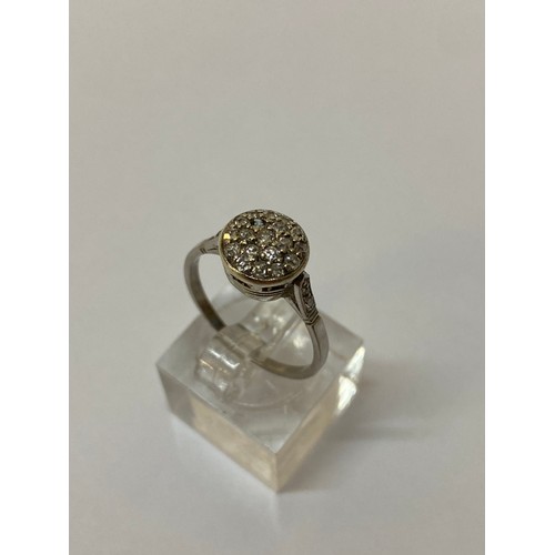 191 - A lady's ring, the top pave set diamonds, on a white metal shank