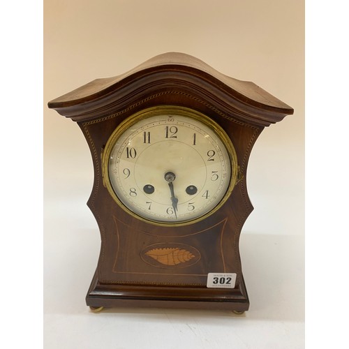 302 - An Edwardian mantel clock with white enamel dial, in a mahogany case with inlaid paterae to the fron... 