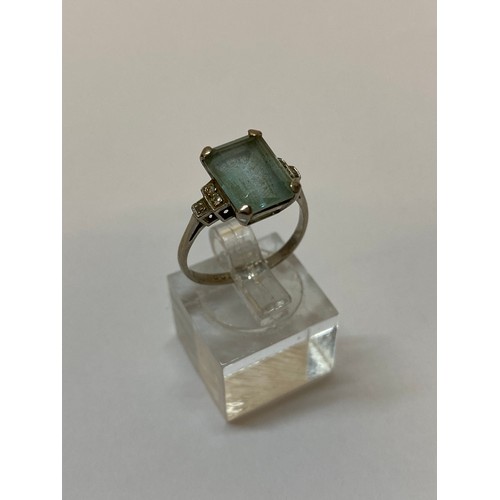 173 - A lady's ring set aquamarine coloured stone with stepped diamond shoulders, on an 18ct. white gold s... 