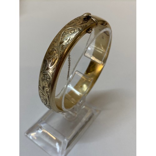 175 - A silver gilt hinged bangle with engraved decoration