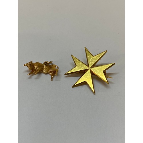 177 - A gold coloured metal brooch in the form of a Maltese cross and a gold coloured metal charm in the f... 
