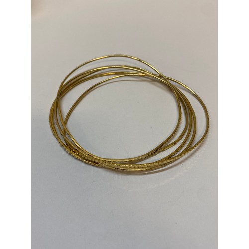 185 - Five gold coloured metal bangles