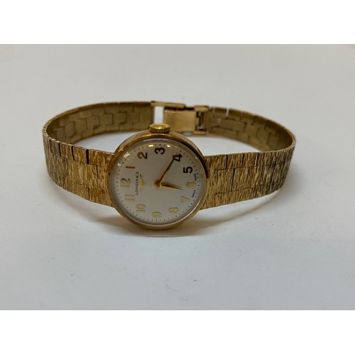 192 - A lady's Longines wristwatch with circular dial, in a 9ct. gold case, on a 9ct. gold bark finished i... 