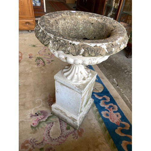 78 - A pair of white painted concrete garden urns with lobed decoration, on pedestal bases standing on pl... 