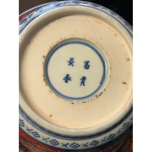 102 - A Japanese Arita bowl decorated in Imari colours with cranes and flowers in alternate panels, four c... 