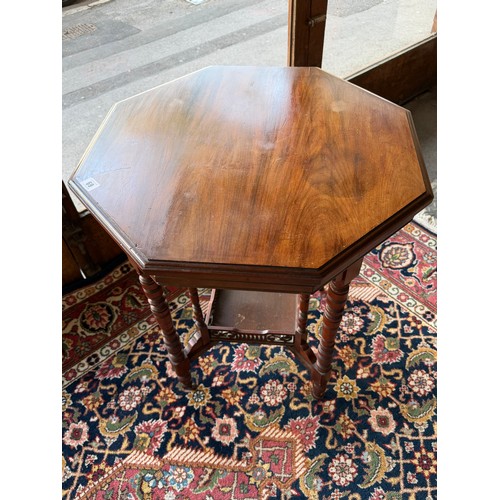 69 - An Edwardian walnut occasional table with octagonal top, on ring turned legs terminating in brown po... 