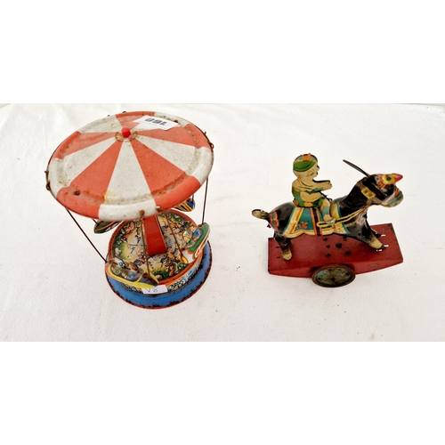 160 - Two vintage tin plate clockwork toys, carousel and riding figure, British made