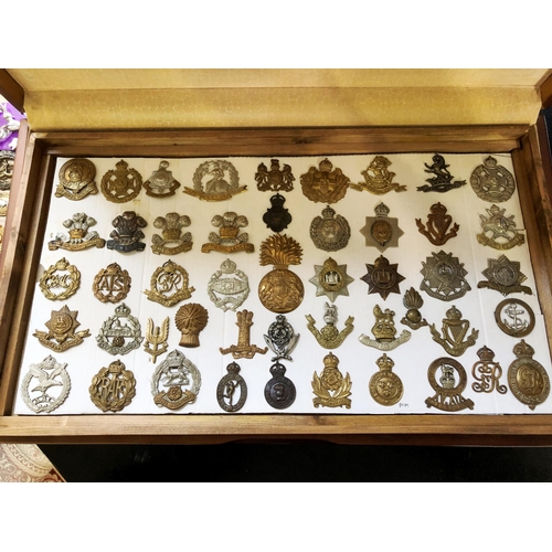 216 - Collection of c.150 British regimental and military cap and other badges in a wooden cabinet