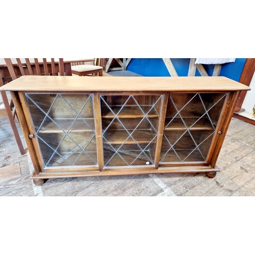 374 - Mahogany glazed bookcase with three leaded sliding doors, one glass panel cracked