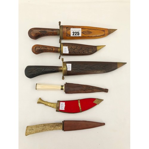 225 - A group of six eastern and Indian daggers, one reproduction, with carved wooden and leather sheaths