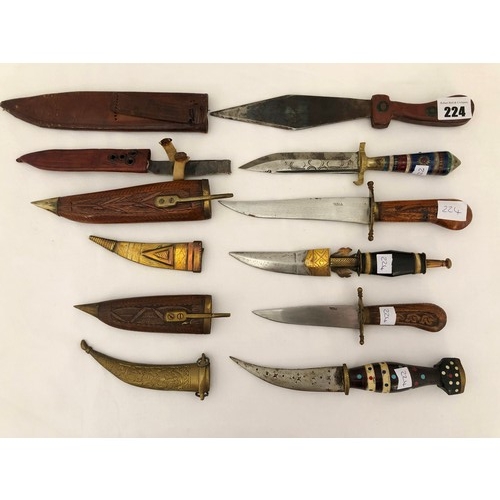 224 - A group of six eastern and Indian daggers with carved wooden brass & leather sheaths