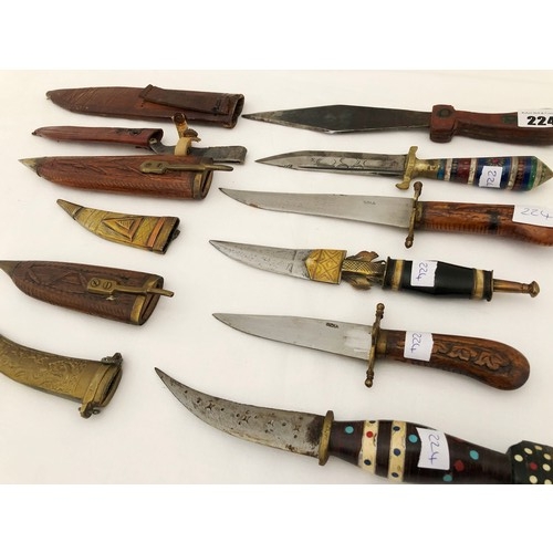 224 - A group of six eastern and Indian daggers with carved wooden brass & leather sheaths