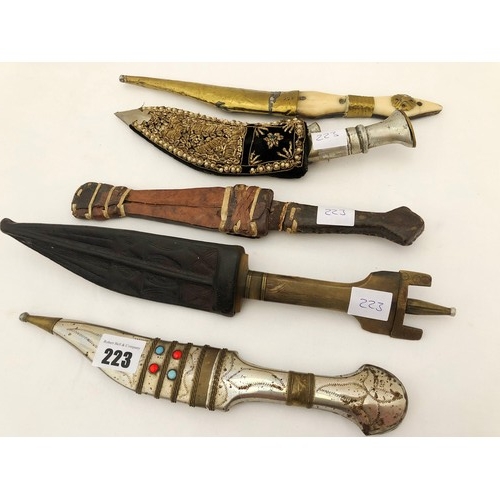 223 - A group of five eastern and Indian daggers, including ornamental jewelled and embroidered sheaths