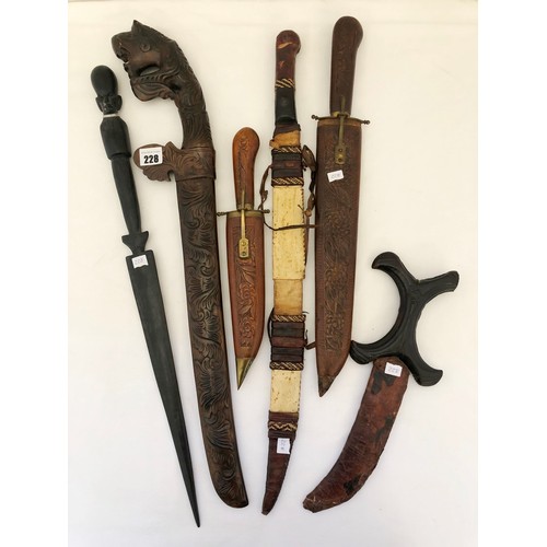 228 - A collection of five eastern and Indian daggers in carved wooden and leather sheaths and a Kenyan ha... 