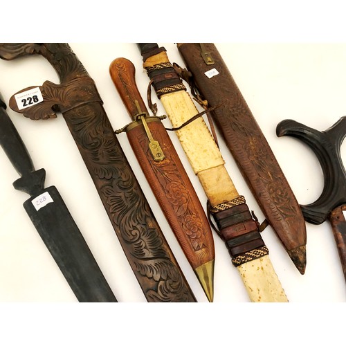 228 - A collection of five eastern and Indian daggers in carved wooden and leather sheaths and a Kenyan ha... 