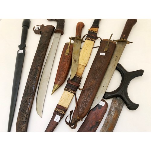 228 - A collection of five eastern and Indian daggers in carved wooden and leather sheaths and a Kenyan ha... 