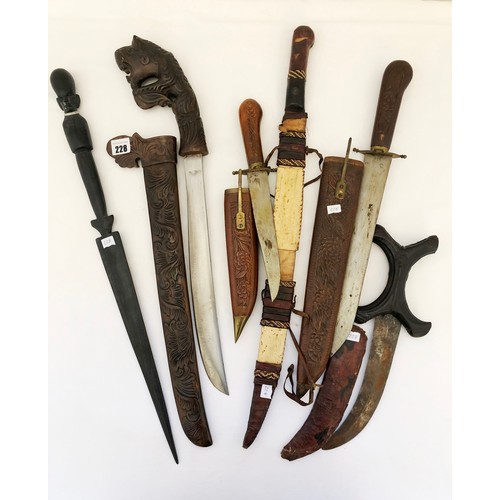 228 - A collection of five eastern and Indian daggers in carved wooden and leather sheaths and a Kenyan ha... 