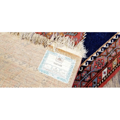 278 - Kashmir blue and red woollen rug, c. 140 x 71 cm