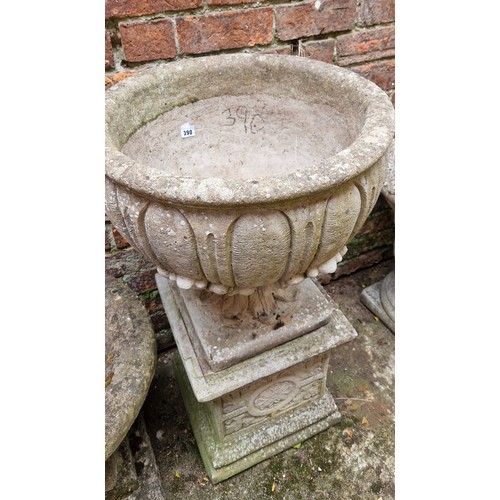 390 - Simulated stone pedestal garden urn on decorative plinth