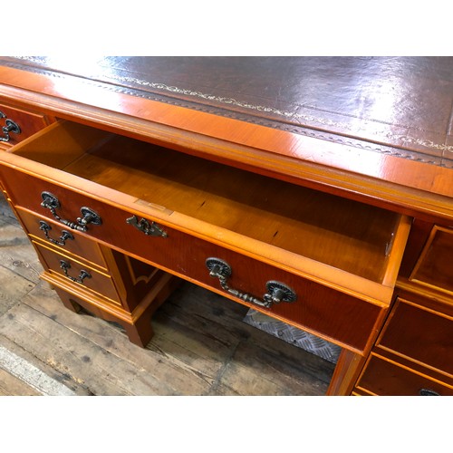 323 - Reproduction yew pedestal desk with tooled leatherette top