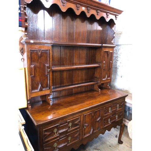 366 - Mid century oak dresser with plate rack and cupboards over a base of drawers and cupboards, geometri... 