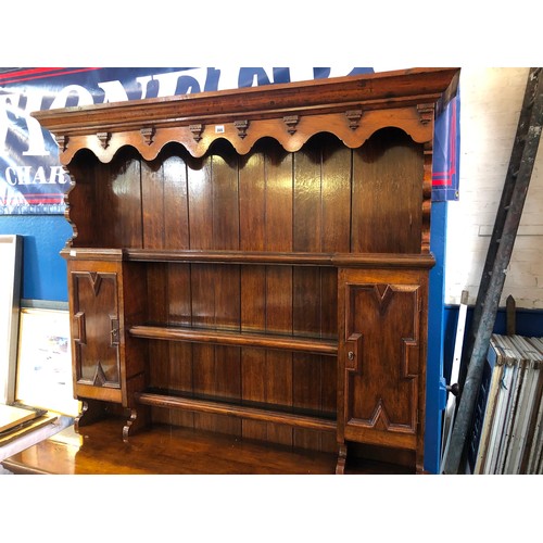 366 - Mid century oak dresser with plate rack and cupboards over a base of drawers and cupboards, geometri... 