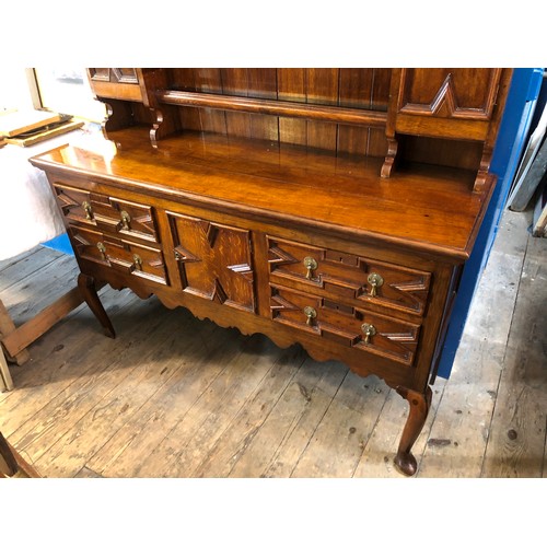 366 - Mid century oak dresser with plate rack and cupboards over a base of drawers and cupboards, geometri... 