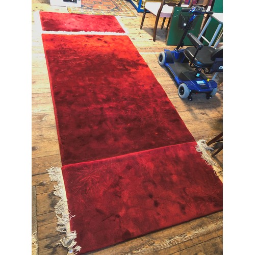 287 - Set of three Chinese red woollen rectangular rugs with relief bamboo decoration, c. 95