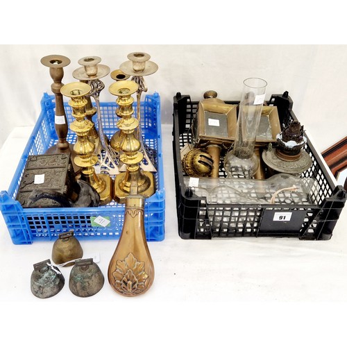 91 - Two baskets of metalware incl. brass candlesticks, powder flask, oil lamp parts etc