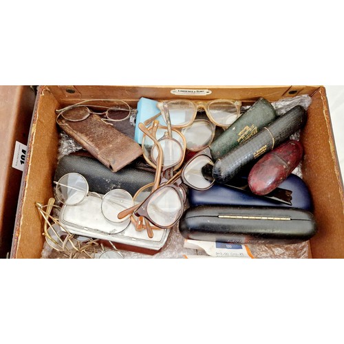 104 - Two small leather box cases, one containing a quantity of cased and loose wire rimmed spectacles etc