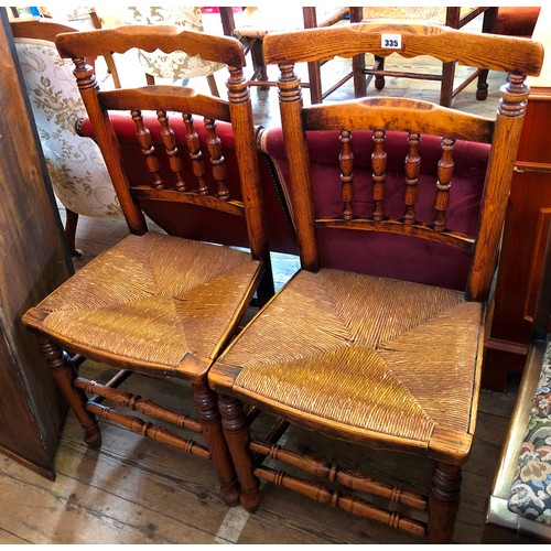 335 - Pair of oak framed spindle back rush seated kitchen chairs