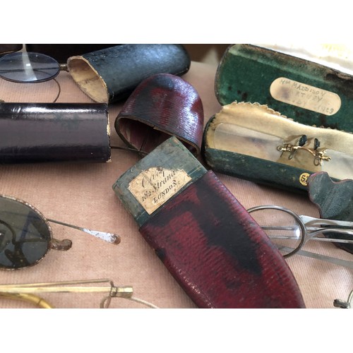 104 - Two small leather box cases, one containing a quantity of cased and loose wire rimmed spectacles etc