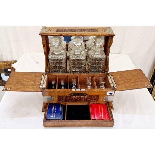 118 - Oak three bottle tantalus with carved decoration and metal mounts and fitted interior