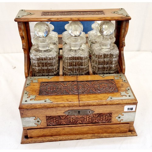 118 - Oak three bottle tantalus with carved decoration and metal mounts and fitted interior