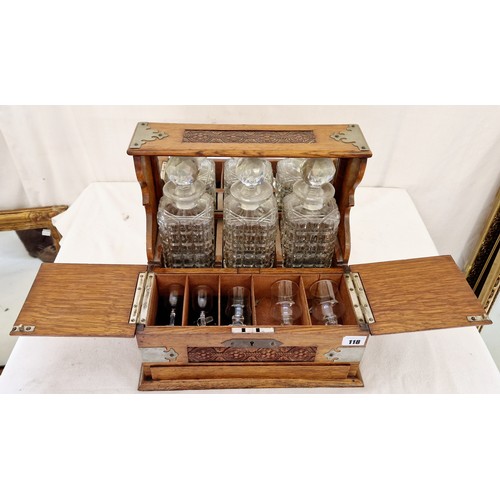 118 - Oak three bottle tantalus with carved decoration and metal mounts and fitted interior