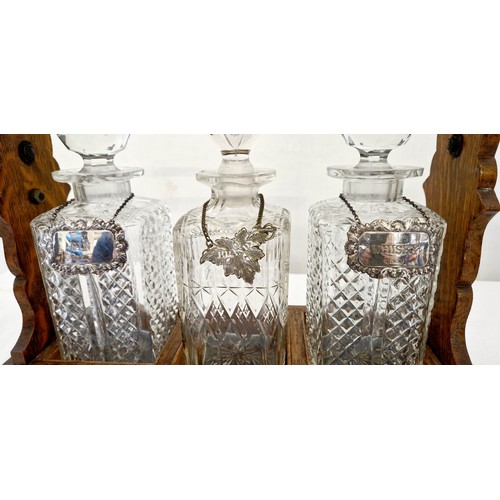 110 - Oak and EPNS 3 bottle tantalus with 2 silver labels for whiskey and gin