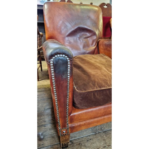 284 - An Edwardian leather armchair with cloth seat and brass studding