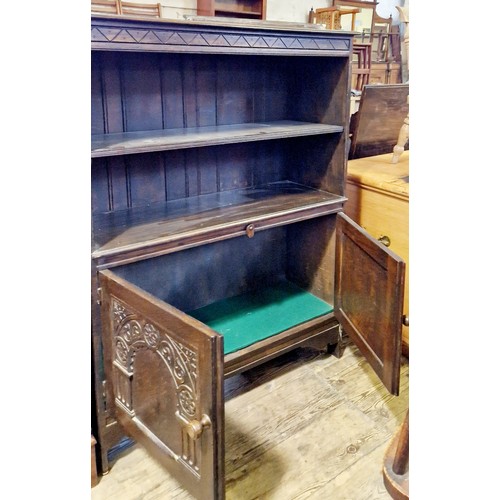 301 - A mid-century oak 2-tier open bookcase on cupboard base with relief doors