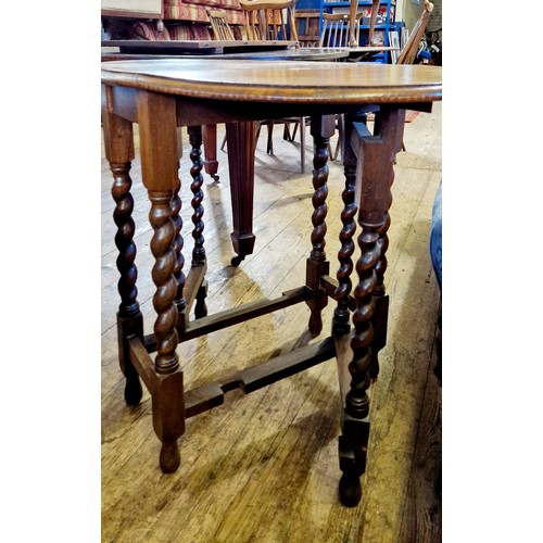 304 - A mid-century oak oval drop leaf table on barley twist legs