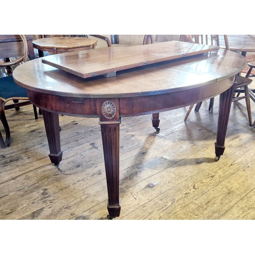 305 - An early 20th century oval mahogany extending dining table on fluted and square legs to brass castor... 