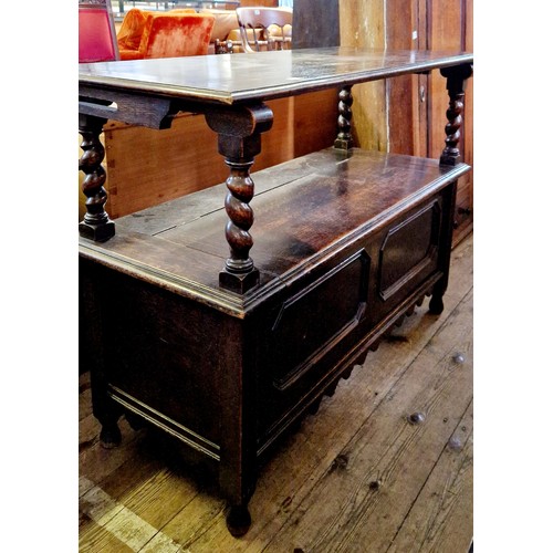 310 - An early 20th century oak monks seat with relief carved panels and barley twist supports