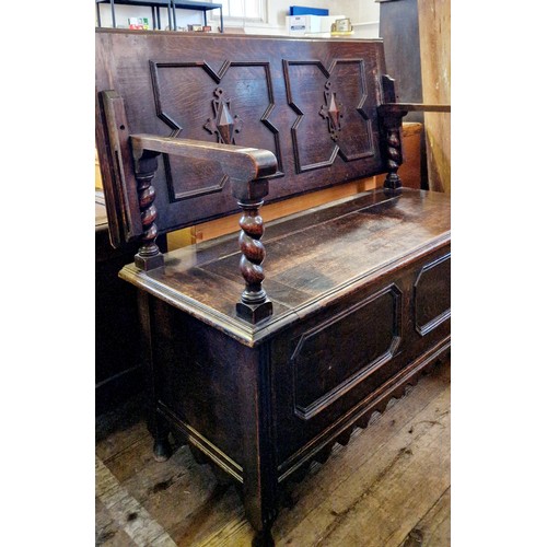 310 - An early 20th century oak monks seat with relief carved panels and barley twist supports