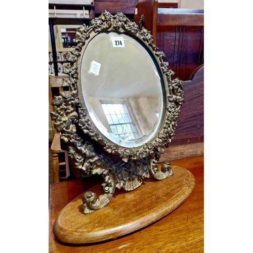 274 - Oval swing toilet mirror with pierced foliate surround with bevelled plate on wooden plinth