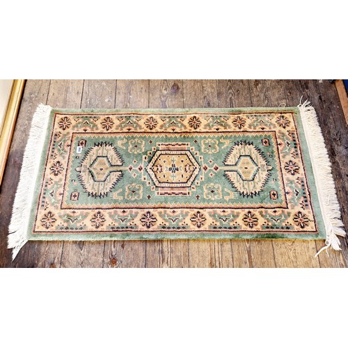 200 - Patterned green woollen rug approx. 123cm x 62cm