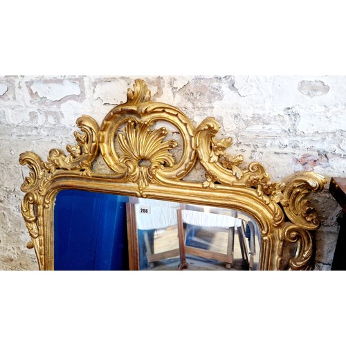 206 - Reproduction ornate rectangular giltwood wall mirror with shaped and pierced foliate surround and be... 