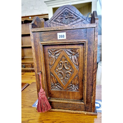 260 - Early 20th century small oak cabinet with carved panels and shelved interior