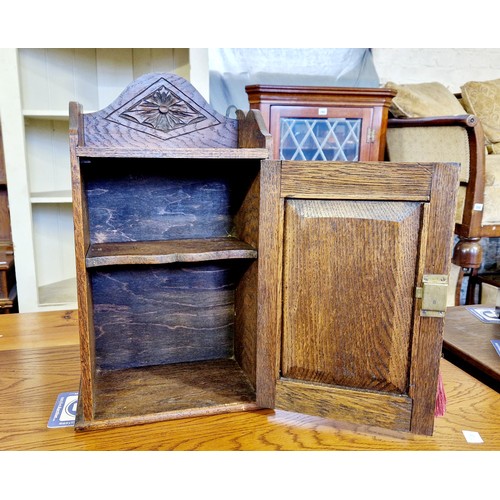 260 - Early 20th century small oak cabinet with carved panels and shelved interior